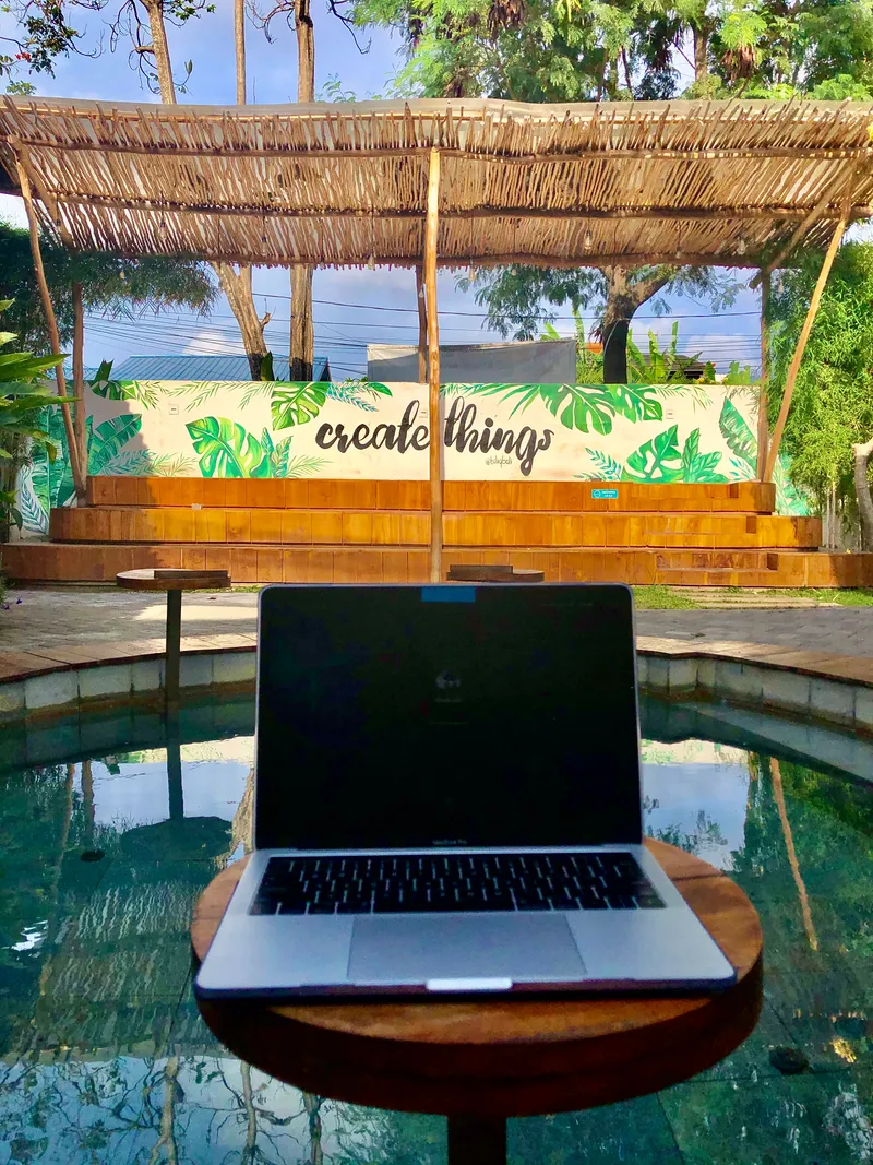Laptop on a desk with a 'create things' mural behind it