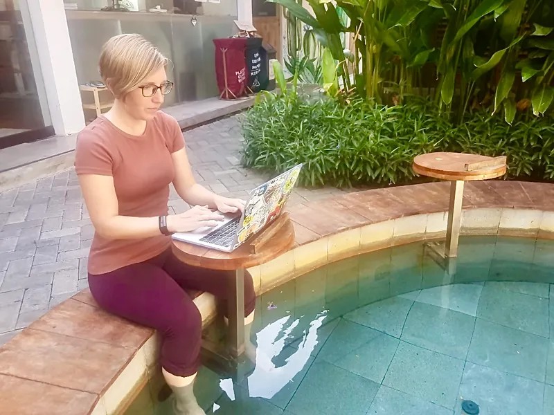 Working on a laptop beside a pool